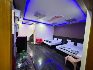 a room with two beds and a blue light at SAMRAT HOME STAY in Hampi