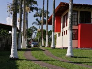 a row of palm trees in front of a house at Finca villa carolina, eje cafetero in La Floresta