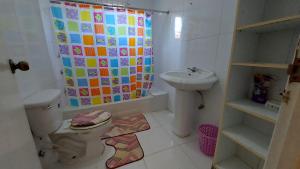a bathroom with a toilet and a shower curtain at Mackenzie Guest House in Clifton