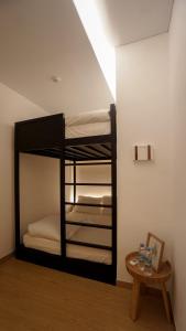 ManukabyHavis Boutique Hotel في ناغويا: سرير بطابقين في غرفة مع طاولة