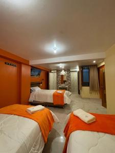 een hotelkamer met 2 bedden en een badkamer bij casa marfil tourist house in Cuzco