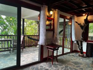 Habitación con puertas de cristal y balcón con mesa. en Mai Pen Rai Bungalows en Than Sadet Beach