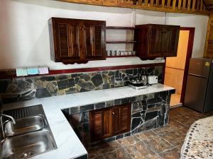 a kitchen with wooden cabinets and a sink and a counter top at Mai Pen Rai Bungalows in Than Sadet Beach