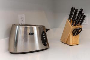 einen Toaster auf einer Theke neben einem Holzblock mit Messern in der Unterkunft Single detached house with 3 BRM in Edmonton
