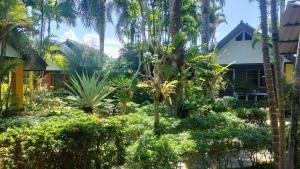 einen Garten vor einem Haus mit Palmen in der Unterkunft Sanuk Bungalow in Khao Lak