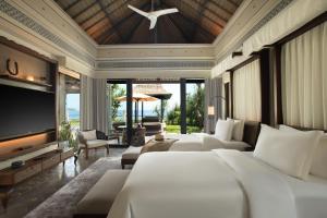 a bedroom with four beds and a flat screen tv at Jumeirah Bali in Uluwatu