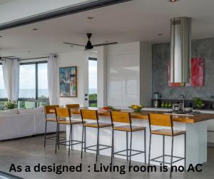 a kitchen with a kitchen island with bar stools at Bay Villas Koh Phangan in Salad Beach