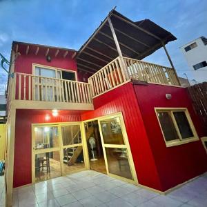 una casa roja con balcón en la parte superior. en La Casa Roja Cerro Azul en Cerro Azul