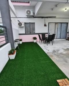 un bureau avec un tapis vert dans une chambre dans l'établissement Sakura Thirty Guest House , Homestay Seri Iskandar, à Seri Iskandar