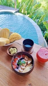 een dienblad met eten op een tafel naast een zwembad bij Kalma Bamboo Eco Lodge in Kuta Lombok