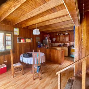 una sala da pranzo con tavolo e una cucina di La Casa Roja Cerro Azul a Cerro Azul