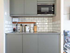 a kitchen with white cabinets and a microwave at Duplex 7 pers avec WIFI, balcon à Avoriaz - FR-1-314-246 in Morzine