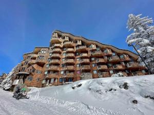 a large building in the snow with a snowmobile at Appartement Avoriaz, 2 pièces, 5 personnes - FR-1-314-261 in Morzine