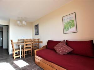 a living room with a red couch and a table at Appartement Avoriaz, 2 pièces, 5 personnes - FR-1-314-268 in Morzine