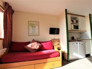 a small room with a red couch and a kitchen at Appartement Avoriaz, 2 pièces, 5 personnes - FR-1-314-268 in Morzine