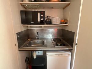 eine kleine Küche mit einer Spüle und einer Mikrowelle in der Unterkunft Studio Avoriaz, 1 pièce, 3 personnes - FR-1-314-281 in Morzine
