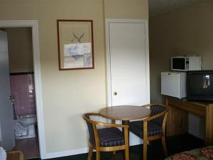 a room with a table and two chairs and a tv at Crestview Inn in Crestview