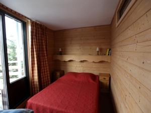 um quarto com uma cama vermelha num quarto de madeira em Appartement Avoriaz, 3 pièces, 6 personnes - FR-1-314-249 em Morzine