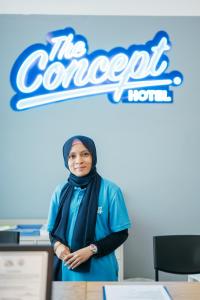 a woman standing in front of a sign at The Concept Hotel Melaka City in Melaka