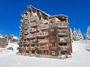 un grand bâtiment en bois dans la neige dans l'établissement Studio Avoriaz, 1 pièce, 4 personnes - FR-1-314-266, à Morzine