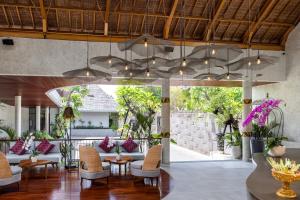 The Hava Ubud A Pramana Experience في أوبود: غرفة معيشة بها كنب وكراسي وسقف