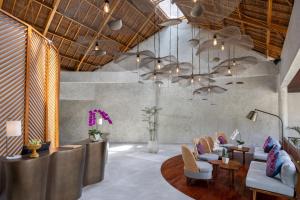 a lobby with a waiting area with chairs and tables at The Hava Ubud A Pramana Experience in Ubud