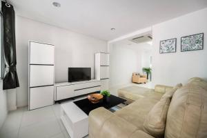 a living room with a couch and a television at MIQ_home901/Asok BTS/Resort Pool/12pax/1000MbWifi in Bangkok