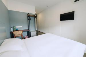 a bedroom with a bed and a flat screen tv at The Concept Hotel Melaka City in Melaka