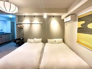 a bedroom with a large white bed in a room at LOVE UENO 2-4人アクセス抜群 山手線3分 上野浅草銀座近い 御徒町駅3分 アメ横3分 上野駅10分 上野広小路駅3分 湯島駅2分 和風畳寝室 in Tokyo