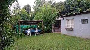 una mesa y sillas en el patio trasero de una casa en quinta el ensueño en General Rodríguez