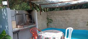 un patio con mesa, sillas y parrilla en quinta el ensueño en General Rodríguez