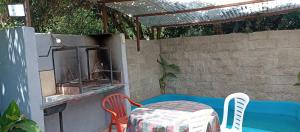 a patio with a table and chairs and a grill at quinta el ensueño in General Rodríguez