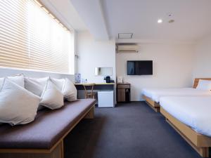 um quarto de hotel com duas camas e uma televisão em You Style Hotel MARINE em Kagoshima