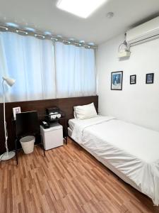 a bedroom with two beds and a desk with a computer at Ekonomy Haeundae Hostel in Busan