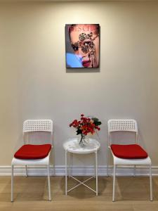 2 chaises et une table avec un vase de fleurs dans l'établissement BRAND NEW home with EXCLUSIVE Bathroom, à Toronto