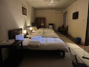 a bedroom with two beds and a desk and a bed at Crown Castle Peshawar in Peshawar