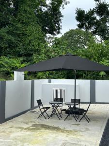 einen Tisch und Stühle mit Sonnenschirm auf einer Terrasse in der Unterkunft elyssa_homes in Kota Bharu