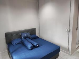Phenn's House @Ramkhamhaeng في Bang Kapi: سرير بملاءات ومخدات زرقاء في الغرفة