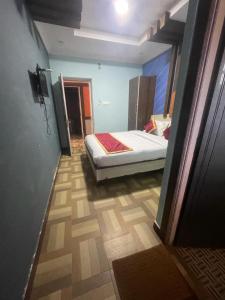 1 dormitorio con 1 cama en una habitación con pasillo en Ooty OWLS NEST INN en Ooty