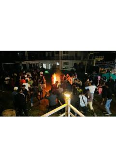 a crowd of people standing around a fire at Ooty OWLS NEST INN in Ooty