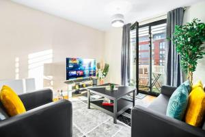 a living room with two couches and a tv at Modern Arcadian Center Apartment By Azura Nights in Birmingham