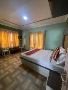 sypialnia z dużym łóżkiem w pokoju w obiekcie Ooty OWLS NEST INN w mieście Utakamand