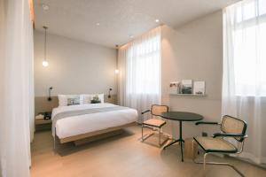 a bedroom with a bed and a table and chairs at Read and Rest Hotel in Beijing