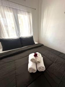 ein Bett mit Handtüchern und einem Fenster in der Unterkunft MONA NEST Canggu 2BR Tiny House with Rooftop and Cozy Workspace in Dalung + 14 Fotos