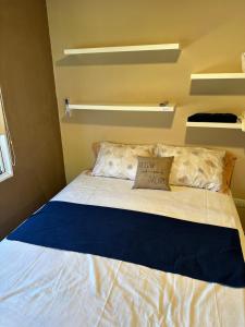 Deán Funes的住宿－La Palmera，一张位于小房间的床,配有蓝色毯子