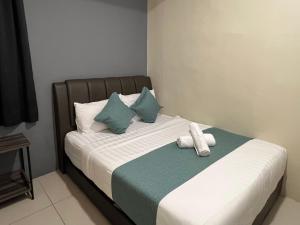 een slaapkamer met een bed met handdoeken erop bij KUANTAN BESERAH BUDGET HOTEL in Kuantan