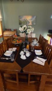a dining room table with a wooden table with flowers on it at Belvedere Bed & Breakfast in Winton