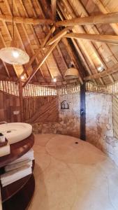 Habitación grande con pared de piedra en un granero en Kalma Bamboo Eco Lodge en Kuta Lombok