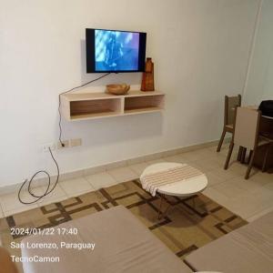 a living room with a flat screen tv on a wall at Departamento en San Lorenzo in San Lorenzo