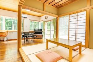 ein Wohnzimmer mit einem Tisch und einem Esszimmer in der Unterkunft Green Oasis Cottage Hakone Sengokuhara - グリーンオアシスコテージ箱根仙石原 in Sengokuhara